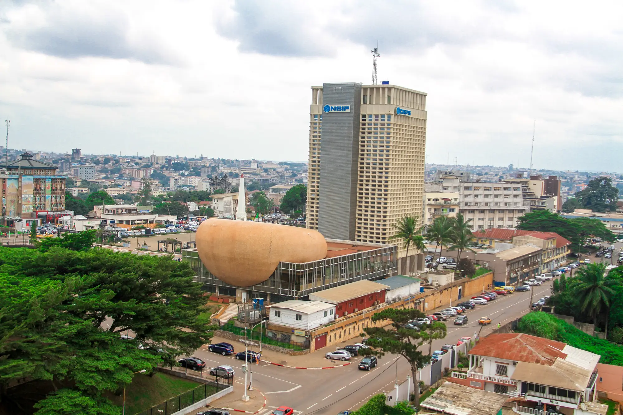 Central Yaoundé from above: a high-rise tower, a domed building and tree-lined streets.